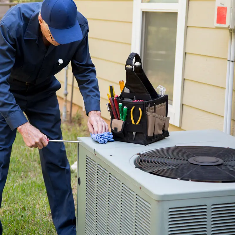 HVAC technician conducting routine AC maintenance